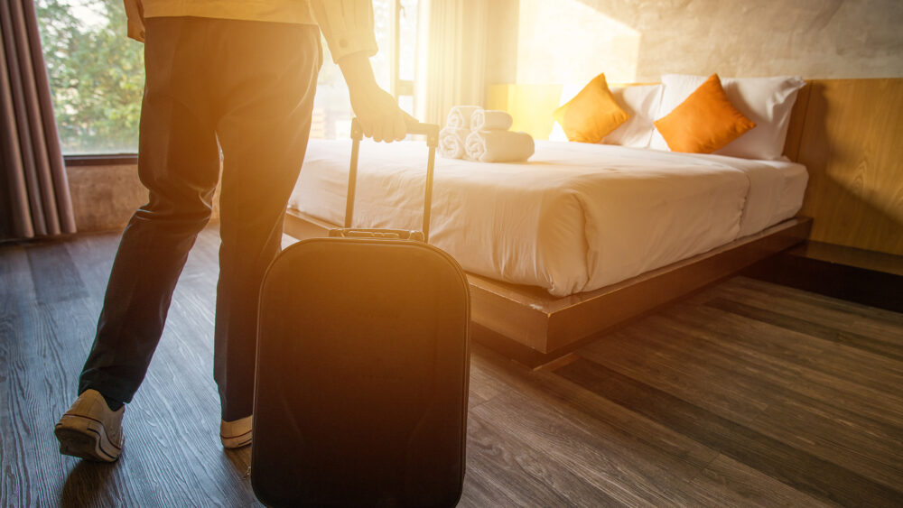 une personne tient une valise dans une chambre